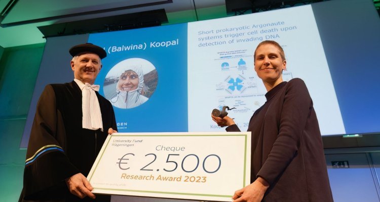 Winner of the Research Award 2023 Bel Koopal with her cheque next to Prof. Wouter Hendriks