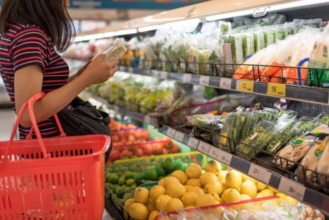 Vrouw bekijkt etiket groentenafdeling supermarkt