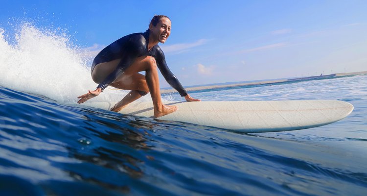 Surf your Stress - Jonge vrouw surft op een grote golf