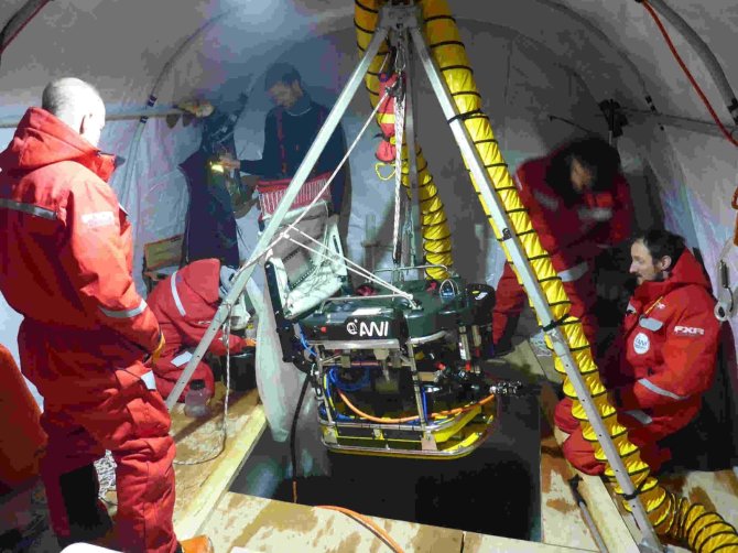 In the ice camp a fishing net is attached to an ROV (remotely operated vehicle) to sample zooplankton directly underneath the ice. The permanent hole in the ice is covered by a tent (Photo: Eric Brossier).