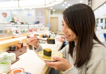 Woman eating sushi with seaweed