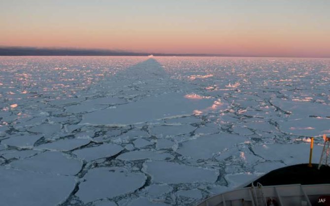 In de middernachtzon werpt Polarstern zijn schaduw tot aan de horizon over het ijs. 