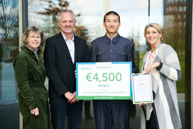 Kang Li stands with Wouter Hendriks, Lies Boelrijk and Anne Zaal, and his price of 4500 euros. Photo: Art van Grondelle.