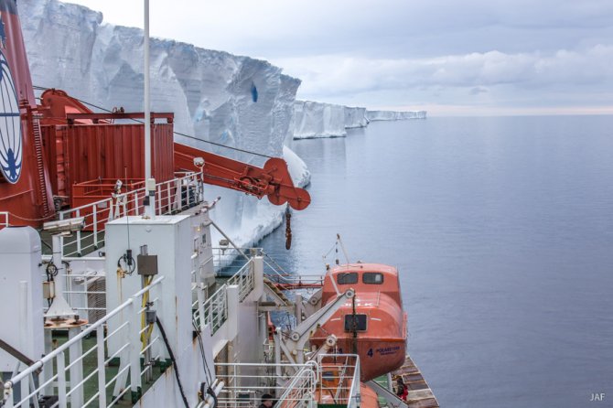 De rand van de ijsshelf op een plek zonder vast zeeijs: te hoog om met de scheepskranen de droge containers te kunnen overzetten, maar nog wel net geschikt om brandstof over te kunnen pompen.